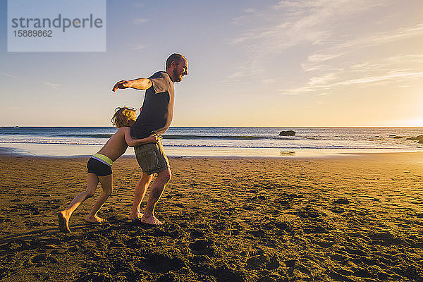 Vater und Sohn beim Spielen und Laufen am Strand