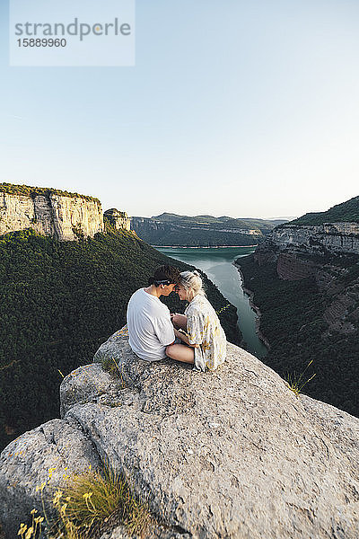 Junges verliebtes Paar sitzt auf Aussichtspunkt  Stausee Sau  Katalonien  Spanien