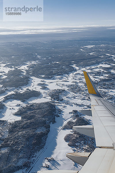 Finnland  Flugzeugflügel überfliegt im Winter bewaldete Landschaft