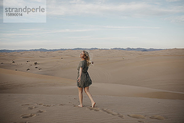 Rückenansicht einer blonden Frau  die auf einer Sanddüne geht  Algodones Dunes  Brawley  USA