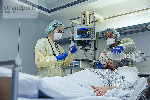 Ärzte mit Beutelventilmaske bei der Versorgung von Patienten auf der Notfallstation eines Krankenhauses