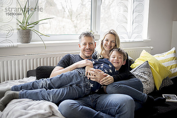 Porträt einer glücklichen Familie  die sich zu Hause auf der Couch entspannt