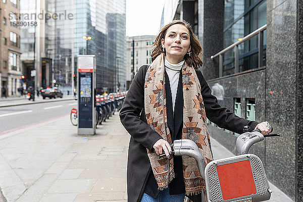 Frau in der Stadt mit Leihfahrrad  London  UK