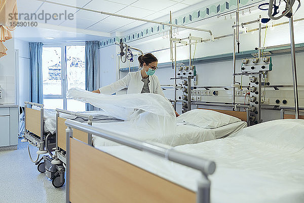 Arzt bereitet Bett im Krankenhauszimmer vor