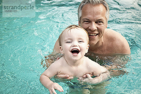 Porträt von Vater und kleinem Sohn zusammen im Schwimmbad  Koh Samui  Thailand