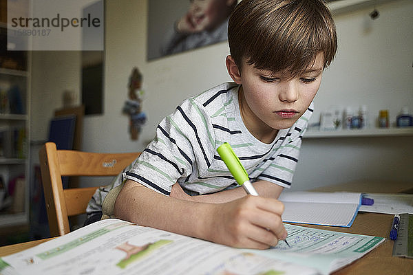 Porträt eines Jungen bei den Hausaufgaben