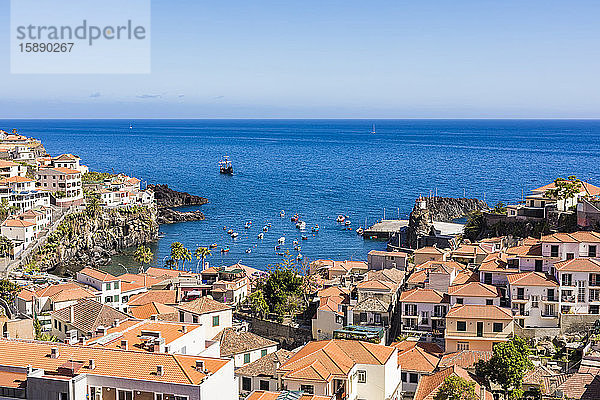 Portugal  Madeira  Camara de Lobos  Häuser einer Küstenstadt mit dem Atlantischen Ozean im Hintergrund