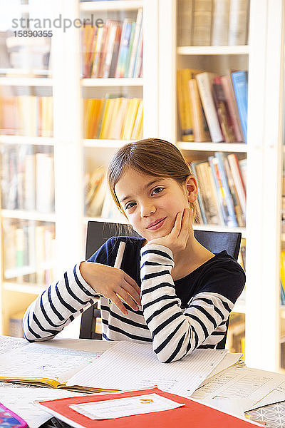 Porträt eines lächelnden Mädchens bei den Hausaufgaben