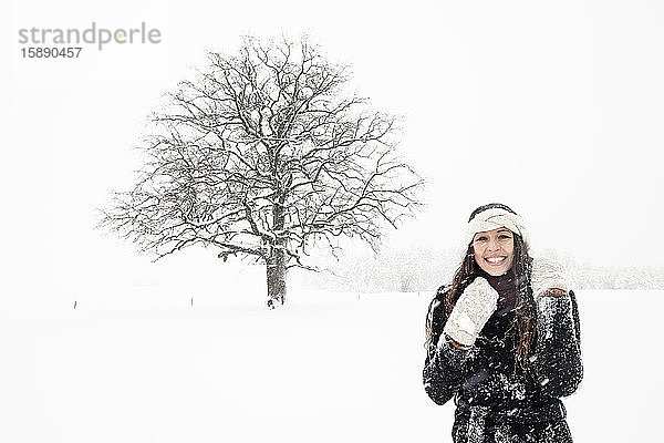 Porträt einer glücklichen jungen Frau in Winterlandschaft