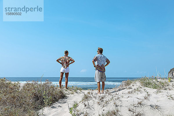 Rückansicht von am Strand stehenden Freunden  Sumbawa  Indonesien