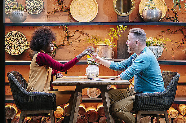 Mann und Frau trinken in einem Restaurant  toastend