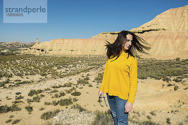 Frau schüttelt ihr Haar in der wüstenhaften Landschaft von Bardenas Reales  Arguedas  Navarra  Spanien