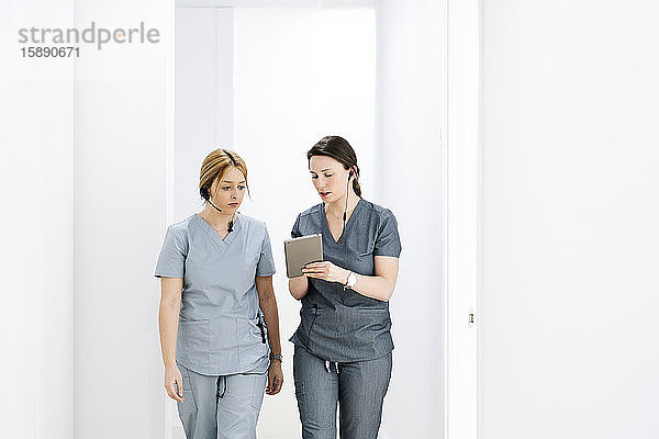 Zwei Arzthelferinnen mit Headset und Tablette in der medizinischen Praxis