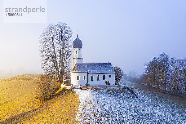 Deutschland  Bayern  Bad Heilbrunn  Drohnenansicht der Kirche Maria Heimsuchung bei nebliger Winterdämmerung