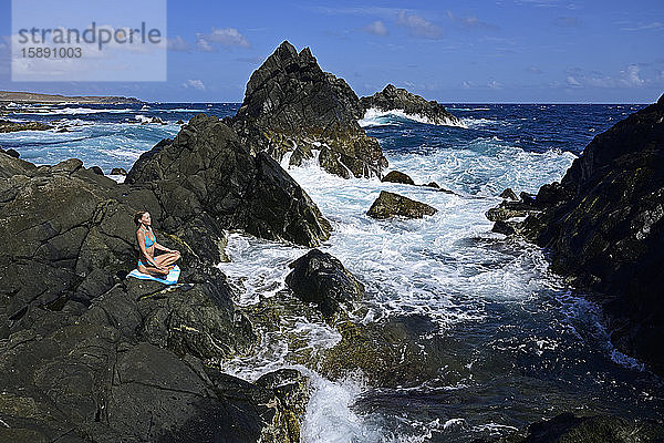 Frau meditiert am Naturschwimmbecken  Arikok-Nationalpark  Aruba  Antillen