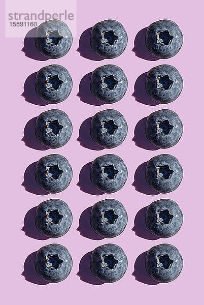 Heidelbeeren in einer Reihe  Muster auf violettem Hintergrund