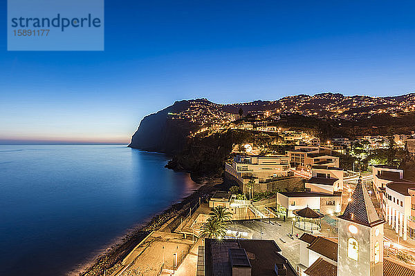 Portugal  Madeira  Camara de Lobos  Langzeitbelichtung einer beleuchteten Küstenstadt in der Abenddämmerung