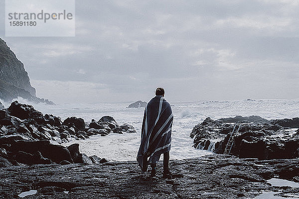 Rückansicht eines an der Küste stehenden Mannes  Sao-Miguel-Insel  Azoren  Portugal