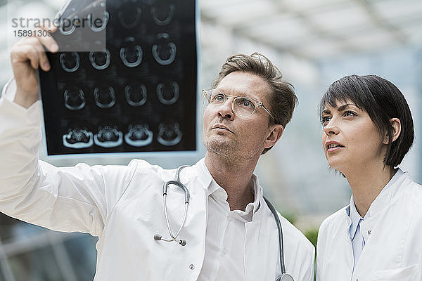 Zwei Ärzte sehen sich Röntgenbilder an