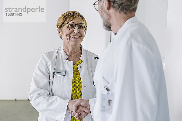 Zwei lächelnde Ärzte beim Händeschütteln