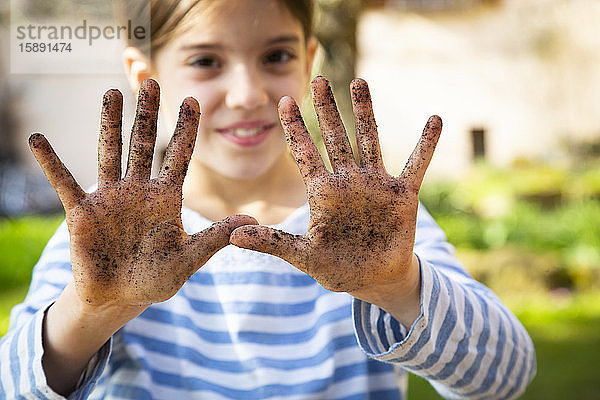 Porträt eines lächelnden Mädchens mit schmutzigen Händen