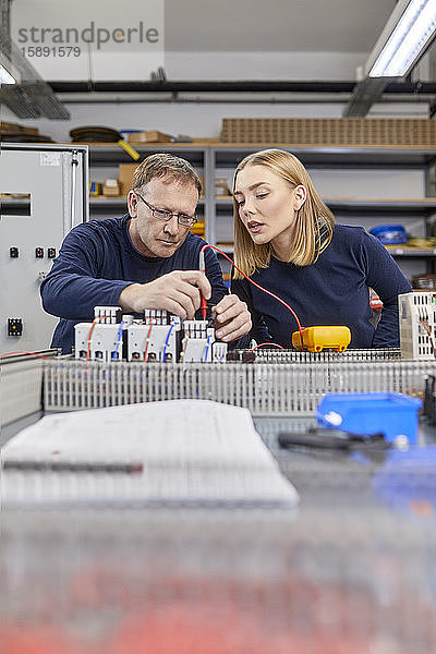 Zwei Elektriker arbeiten in der Werkstatt an Schaltkreisen