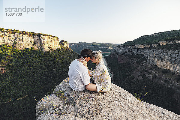 Junges verliebtes Paar sitzt auf Aussichtspunkt  Stausee Sau  Katalonien  Spanien