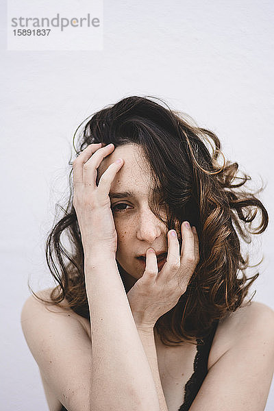 Porträt einer jungen Frau mit Händen im Gesicht