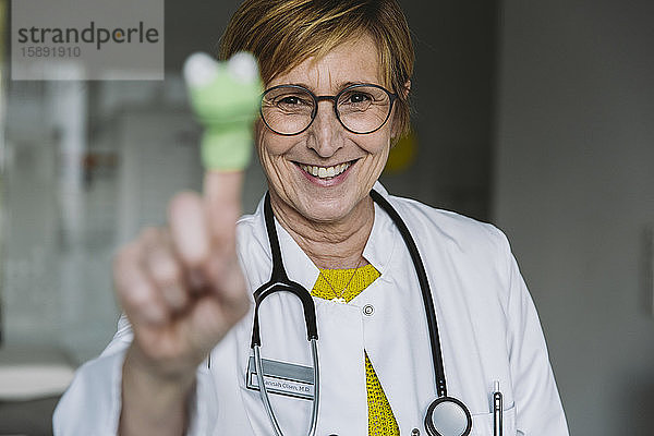 Porträt eines glücklichen Arztes mit Fingerpuppe