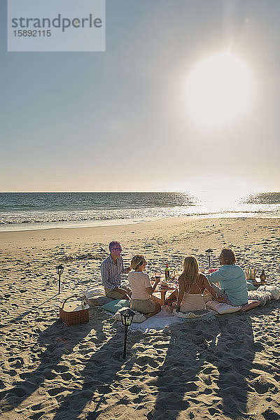 Ältere Freunde im Urlaub  die an sonnigen Tagen ein Picknick am Strand genießen. Riviera Nayarit  Mexiko