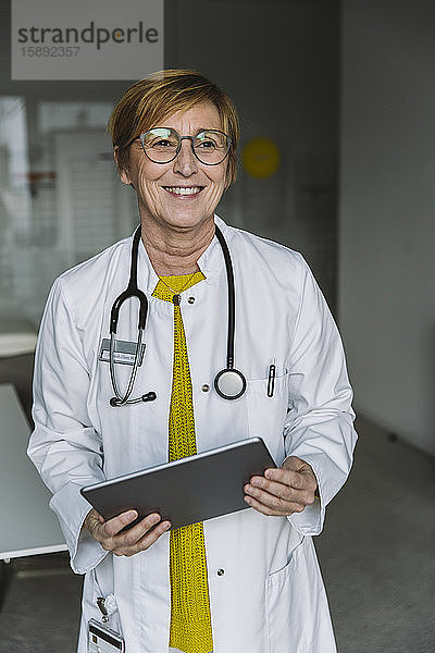 Porträt eines lächelnden Arztes mit Tablette