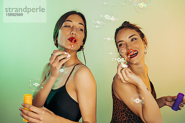 Porträt von zwei Freunden  die Seifenblasen pusten