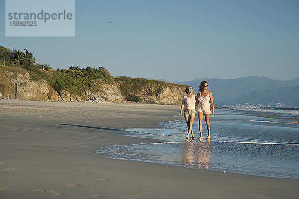 Reife Lesben in voller Länge am Strand vor klarem  blauem Himmel am Strand spazieren gehen  Riviera Nayarit  Mexiko