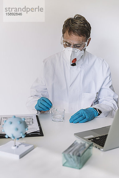 Wissenschaftlerin mit Lateralflussgerät am Schreibtisch