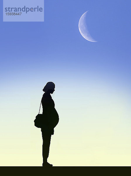 Mond am Himmel über der Silhouette einer schwangeren Frau