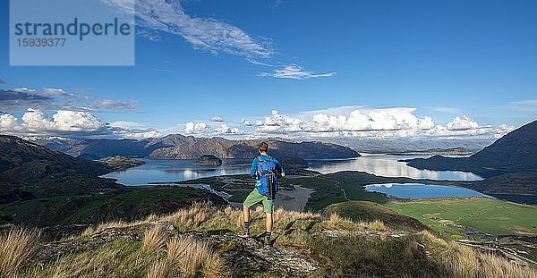 Wanderer hält Ausschau auf Wanaka See und Berge  Rocky Peak  Glendhu Bay  Otago  Südinsel  Neuseeland  Ozeanien