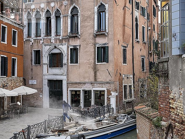 Baustellenschutt wird mit kleinem Schubkarren auf ein Boot gebracht  Venedig  Venetien  Italien  Europa