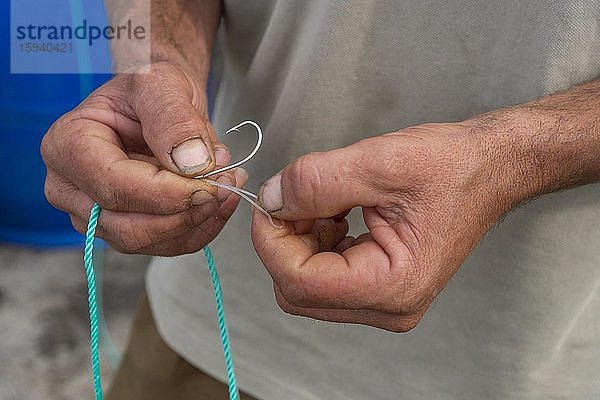 Fischer knotet einen Angelhaken an die Leine  San Miguel  Azoren  Portugal  Europa