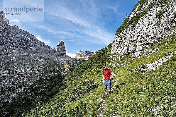 Junger Wanderer auf dem Wanderweg Sentiero Carlo Minazio  hinten Bergspitze des Torre dei Sabbioni  Sorapiss Umrundung  Dolomiten  Belluno  Italien  Europa