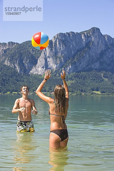 Zwei Teenager spielen mit Wasserball im See  18 Jahre  Mondsee  Oberösterreich  Österreich  Europa