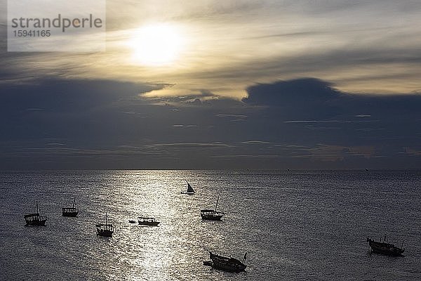 Silhouetten von Fischerbooten im glitzernden Wasser vor Gewitterwolken  Abendstimmung  Sansibar-Stadt  Sansibar  Tansania  Afrika