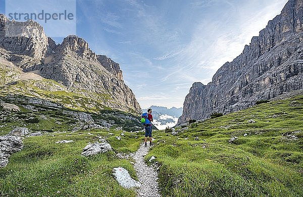 Wanderer  Bergsteiger auf einem Wanderweg zwischen felsigem Gebirge  Sorapiss Umrundung  hinten Berg Punte Tre Sorelle  Dolomiten  Belluno  Italien  Europa