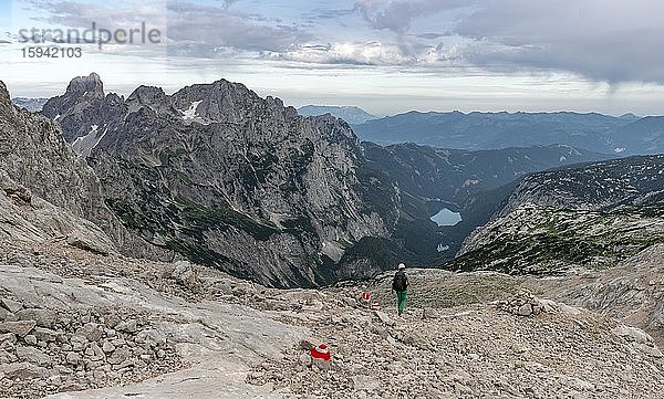 Wanderer auf markiertem Wanderweg von Simonyhütte zur Adamekhütte  felsiges alpines Gelände  Ausblick auf Bergpanorama und Vorderer Gosausee  Salzkammergut  Oberösterreich  Österreich  Europa