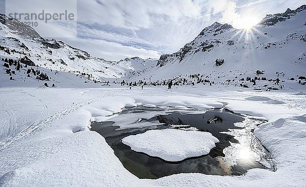 Sonne scheint über schneebedeckte Berggipfel  Klammspitzen und Tarntaler Köpfe  vorne offene Schneedecke mit Wasser  Wattentaler Lizum  Tuxer Alpen  Tirol  Österreich  Europa