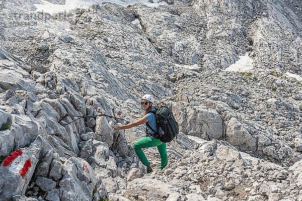 Bergsteigerin auf gesicherter Route von Simonyhütte zur Adamekhütte  felsiges alpines Gelände  Salzkammergut  Oberösterreich  Österreich  Europa