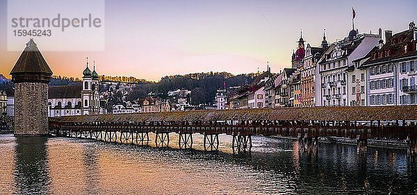 Blick über den Fluss Reuss zur Kapellbrücke  Wasserturm und Jesuitenkirche bei Sonnenuntergang  Altstadt  Luzern  Schweiz  Europa
