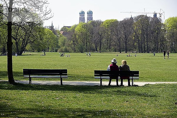 Paar sitzt auf einer Bank im Englischen Garten  Coronakrise München  Oberbayern  Bayern  Deutschland  Europa