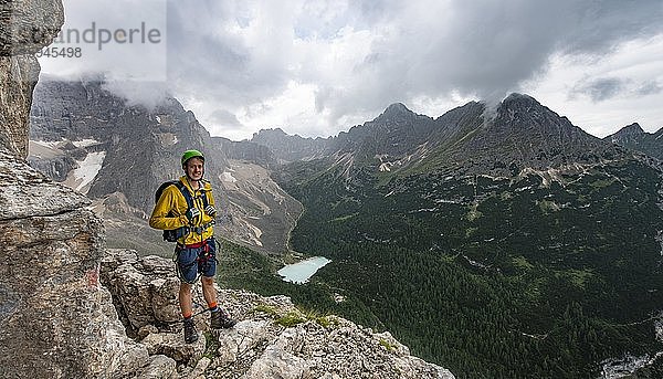 Junger Mann  Wanderer mit Ausblick auf Lago di Sorapis und Berggipfel Cime di Laudo und La Cesta  Klettersteig Via Ferrata Vandelli  Sorapis Umrundung  Dolomiten  Belluno  Italien  Europa