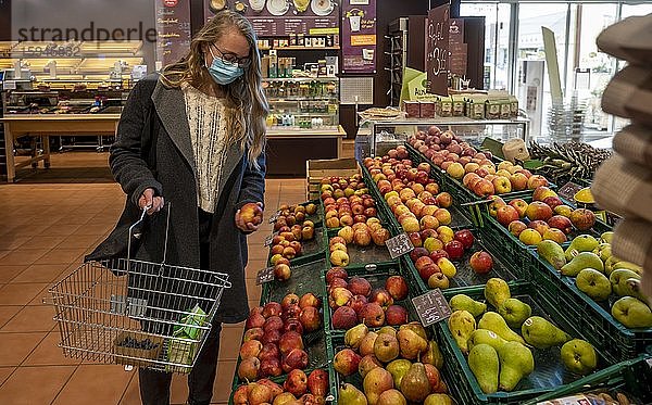 Junge Frau beim Einkaufen im Supermarkt mit Mundschutz  Corona-Krise  Pandemie  Bayern  Deutschland  Europa