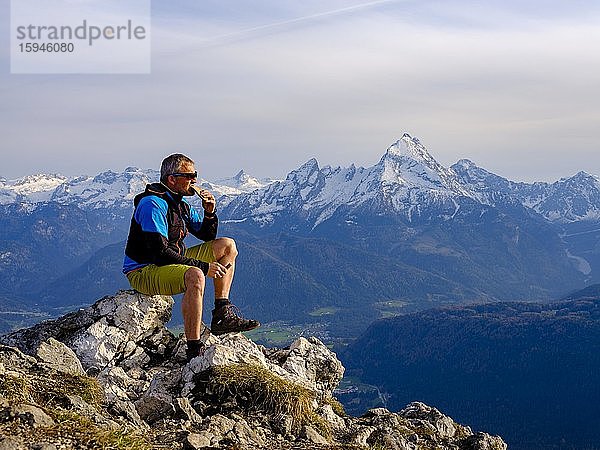 Bergsteiger mit Brotzeit am Berggipfel Rauher Kopf  Berchtesgadener Alpen  hinten Watzmann  Bischofswiesen  Berchtesgadener Land  Oberbayern  Bayern  Deutschland  Europa